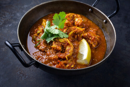 Traditional Indian jhinga masala with king browns served as close-up in a design bowl