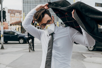 Business man standing or walking on city street with protective face mask. Virus epidemic concept.