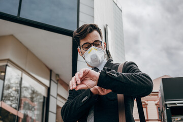 Business man standing or walking on city street with protective face mask. Virus epidemic concept.