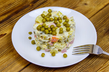 Traditional Russian festive salad Olivier on wooden table