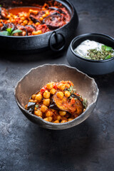 Modern style slow cooked Lebanese vegetarian eggplant stew maghmour served with chickpeas and yoghurt as close-up in a rustic design bowl