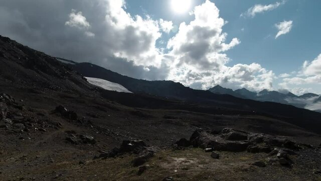 Looking through an abandoned ruined window building at amazing natural landscape. Clip. Mountain range covered by fluffy clouds.