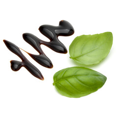 Balsamic vinegar cream and basil leaves isolated on white background. Italian salad dressing, sauce.