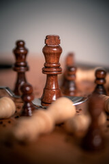 Chess pieces on a wooden table close up photo with king in a silver spoon victorious