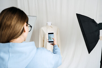 AR VR Technology in Fashion Industry. Female designer shotting clothes on mannequin by cell phone for augmented reality application. AR VR Solutions in Fashion and Retail
