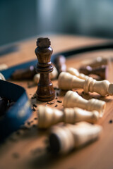 Chess pieces on a wooden table close up photo with king standing victorious