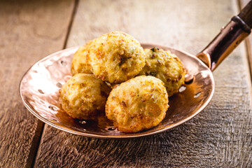 Brazilian rice cake, in the skimmer, common fried snack from Brazil, bar food