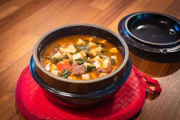 Korean spicy tofu stew in a brown clay pot