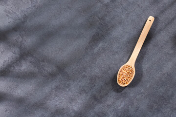 Sinapis alba - Yellow mustard seeds in the wooden spoon