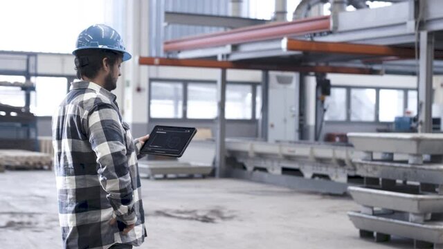 Mann bedienet Tablet in smarter Fabrik