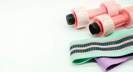 Sport Equipment. Exercises at Home Colorful resistance bands , pink Dumbbells isolated on white Wide. copy space