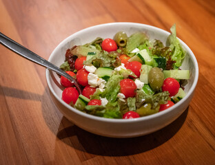 Salad with greens, cherry tomatoes, olive, cucumber, and feta cheese