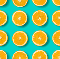 Fruit pattern of orange slices on blue background. Flat lay, top view. Food background.