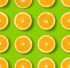 Fruit pattern of orange slices on green  background. Flat lay, top view. Food background.