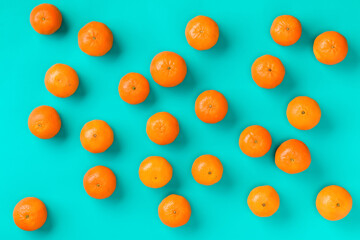 Fruit pattern of fresh mandarin on blue background. Flat lay, top view. Pop art design, creative summer concept. Citrus in minimal style.