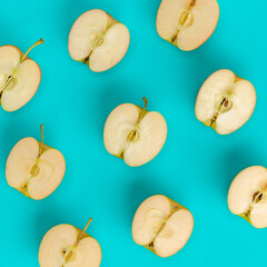 Fruit pattern of apple halves on blue background. Flat lay, top view. Food background.