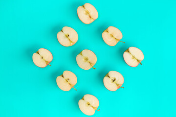Fruit pattern of apple halves on blue background. Flat lay, top view. Food background.