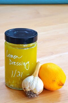 Glass Jar Of Homemade Salad Dressing With Lemon, Garlic And Olive Oil With The Label Written In Chalk