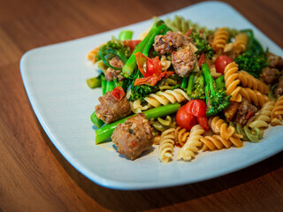 Pasta with meatballs, burst cherry tomatoes, and broccolini