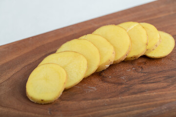 Stack of Sliced potato on brown wooden board