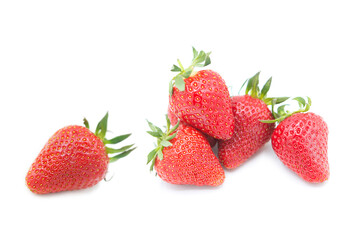 Ripe fresh organic strawberries in a pile and whole with leaves isolated on white background.
