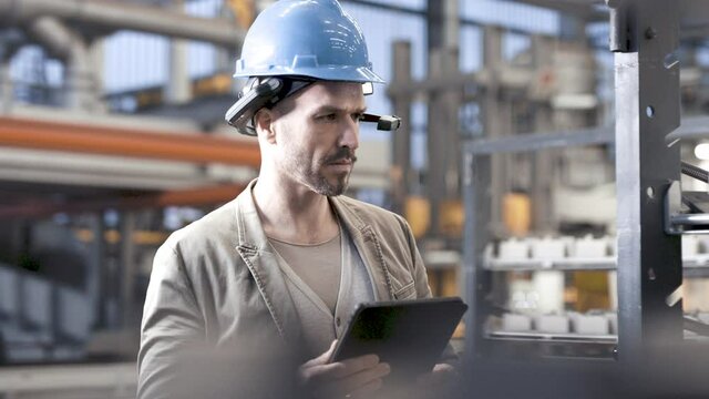 worker using smart augmented reality goggles device in industrial plant company