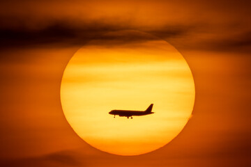 Naklejka na ściany i meble Silhouette of Airplane passing in front of the Sun 