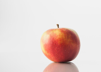 A Single Apple Against White With A Reflection