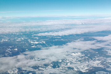 Obraz premium Above clouds and snowy mountains . Aerial winter alpine scenery 