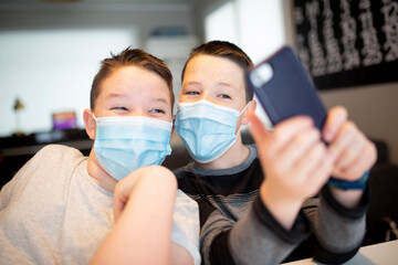 Fototapeta na wymiar two boys in masks taking selfies