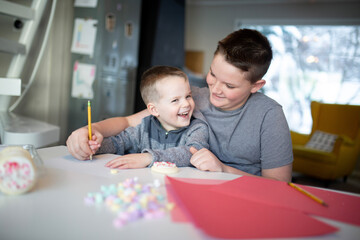 sister helping brother's write valentine's day notes