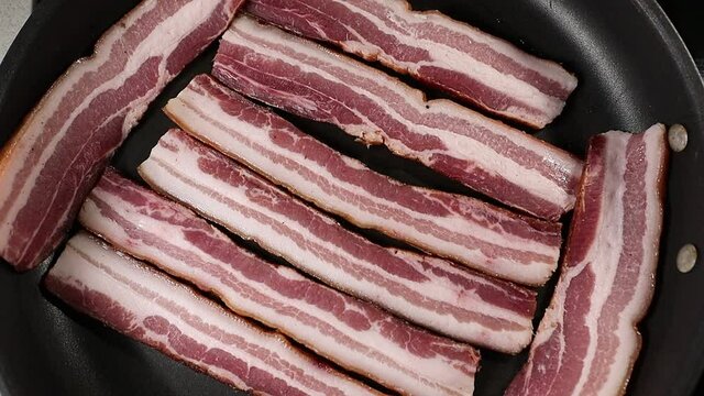 Italian pancetta frying in a pan