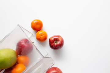 apples, pear, orange, banana pouring out of a blender jar