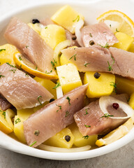 Salted herring with spices and chopped boiled potatoes. Selective focus. Shallow depth of field.
