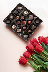 Box of chocolates and red tulips.  Flat lay, top view.