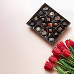 Box of chocolates and red tulips.  Flat lay, top view.