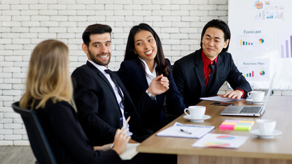 Asian Caucasian businessmen and businesswomen is sitting and discussing work, smiling faces, the atmosphere in the meeting room is good at the office. Concept smile happy meeting Consultation.