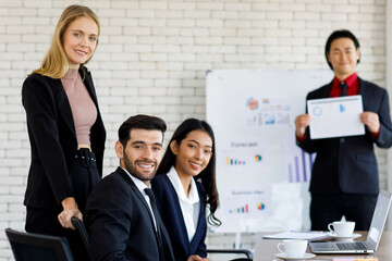 selective focus on Caucasian businesswomen and businessmen the meeting Smiling face to the graph for the attendees. Diversity of nationalities at the meeting room in the office. 