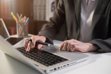 Business women hand working with laptop computer with on office desk in modern office.