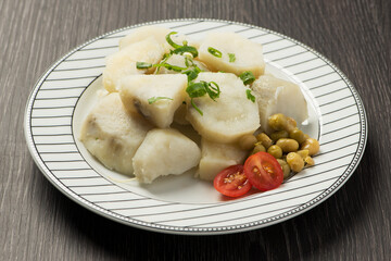 dish with cooked sweet potatoes sprinkled with chives