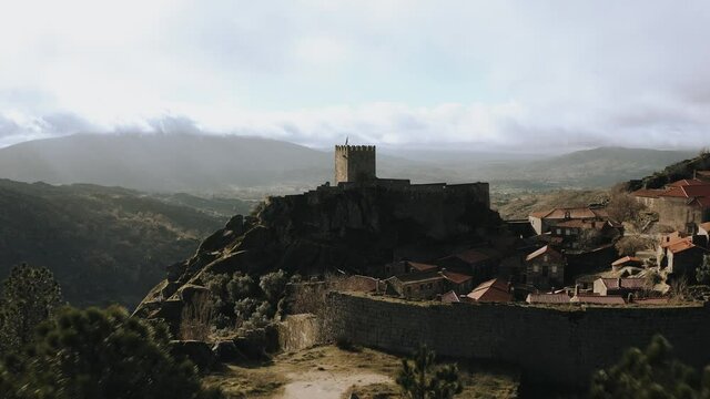Hilltop isolated Medieval castle behind trees, Revealing aerial shot
