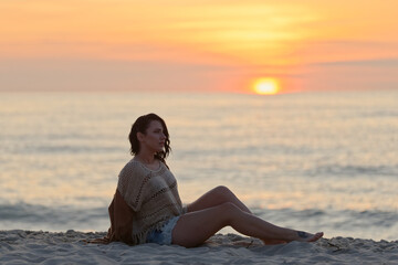 Fototapeta na wymiar woman sitting on the beach