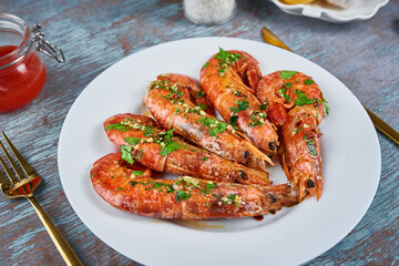 Grilled large queen shrimps with lemon and spices on the plate