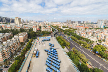 Aerial view of Xiamen BRT (Bus Rapid Transit) station with public buses and the viaducts over city skyline