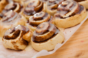 Classic cinnamon rolls cinnabons with creamy frosting on baking paper