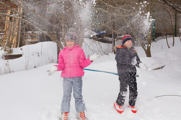 Children throw snow up. Photo in motion. Soft focus.