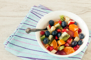 Fresh healthy vitamin fruit salad in a white bowl for a snack. 