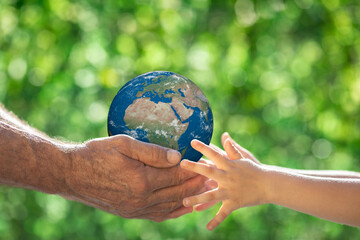 Family holding Earth planet in hands. Elements of this image furnished by NASA