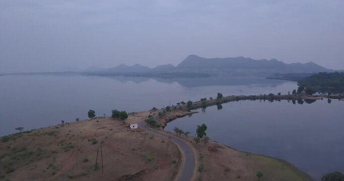 Empty Road With Peaceful Scenery Of Lake Water During Misty Morning At Trimbakeshwar Western Ghats Of India. - Aerial Wide Shot