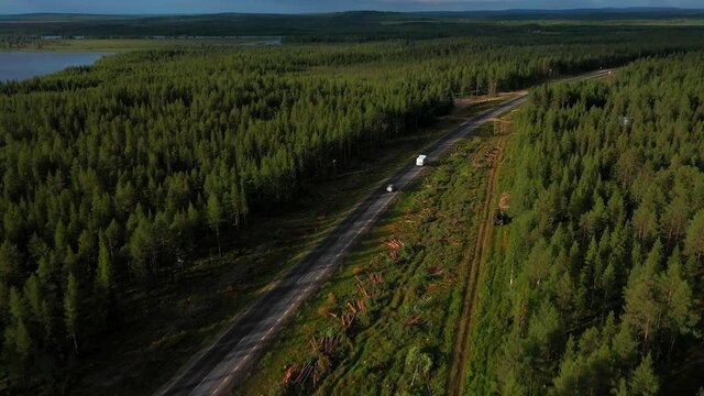 Aerial drone view following a camper driving in polar nature, sunny, summer day